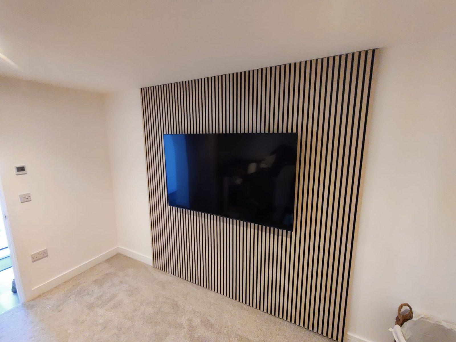 Oak slatted acoustic feature wall with a wall-mounted TV