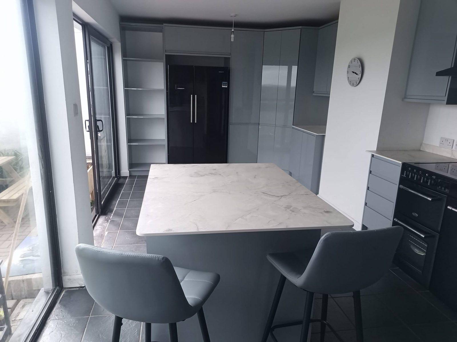 Grey gloss kitchen with island and bifold doors to the garden