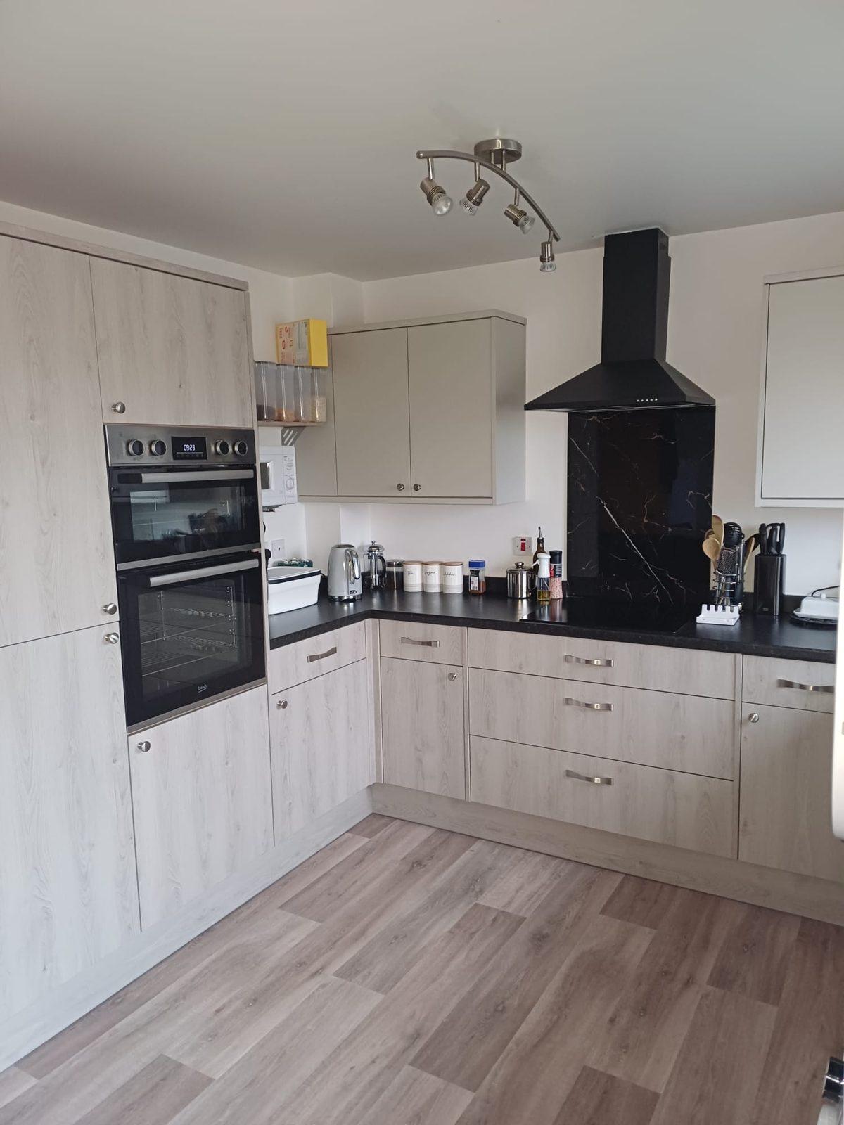 Grey shaker kitchen with double oven and marble-effect splashback