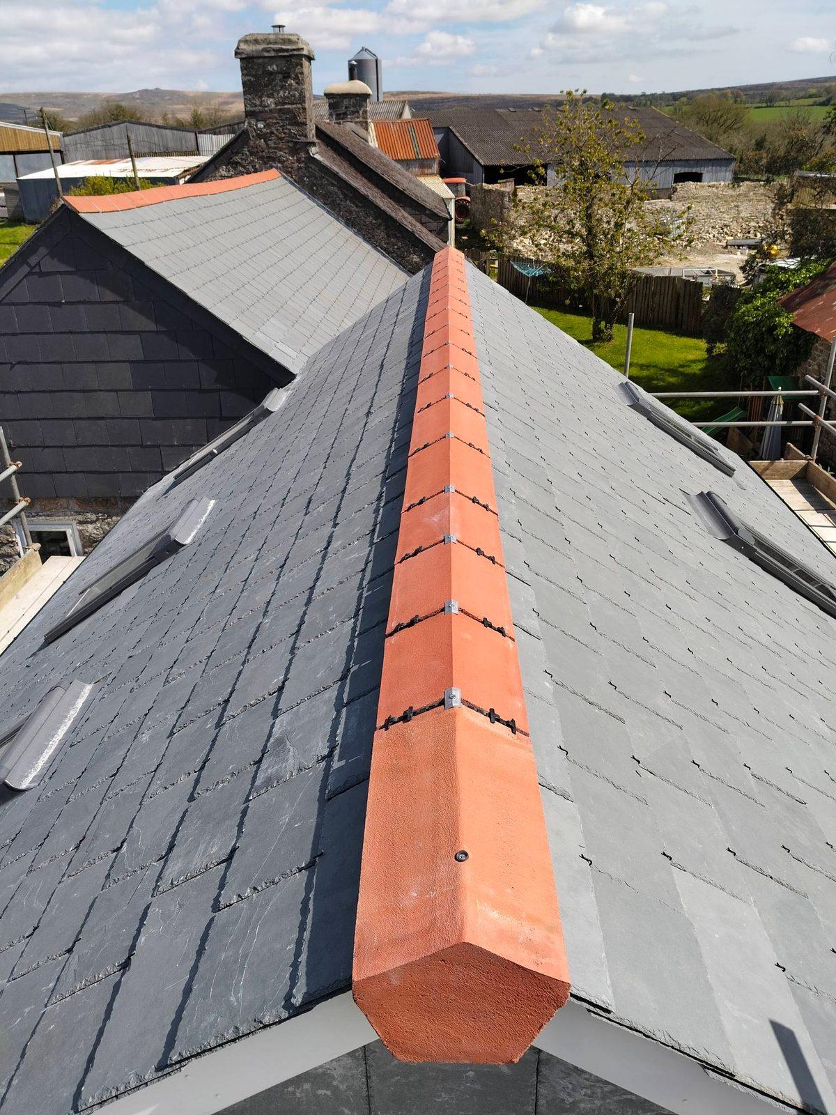 Slate roof with terracotta ridge over a stone farmhouse