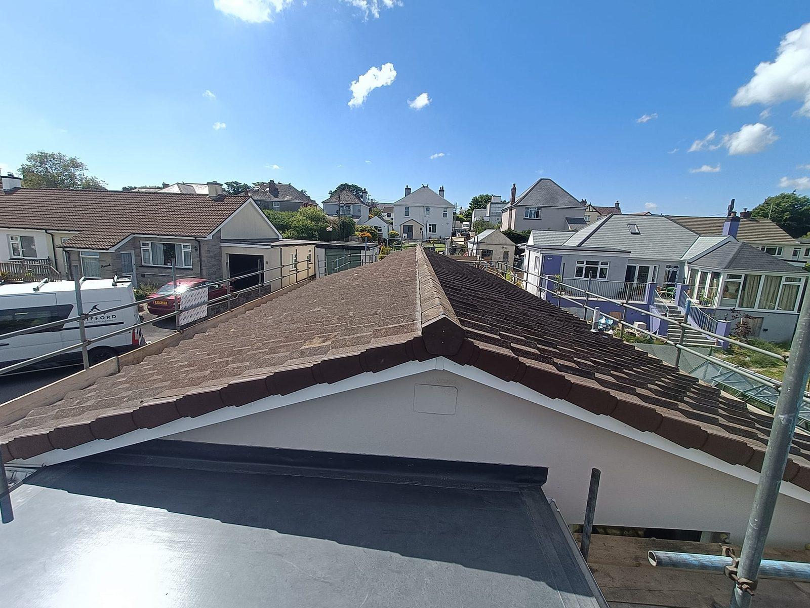 Newly tiled pitched roof with flat-roof section