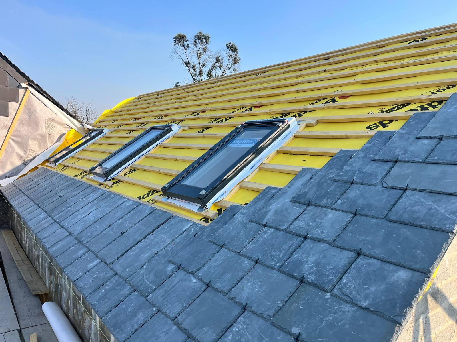 New slate roof in progress with Velux skylights and breathable membrane